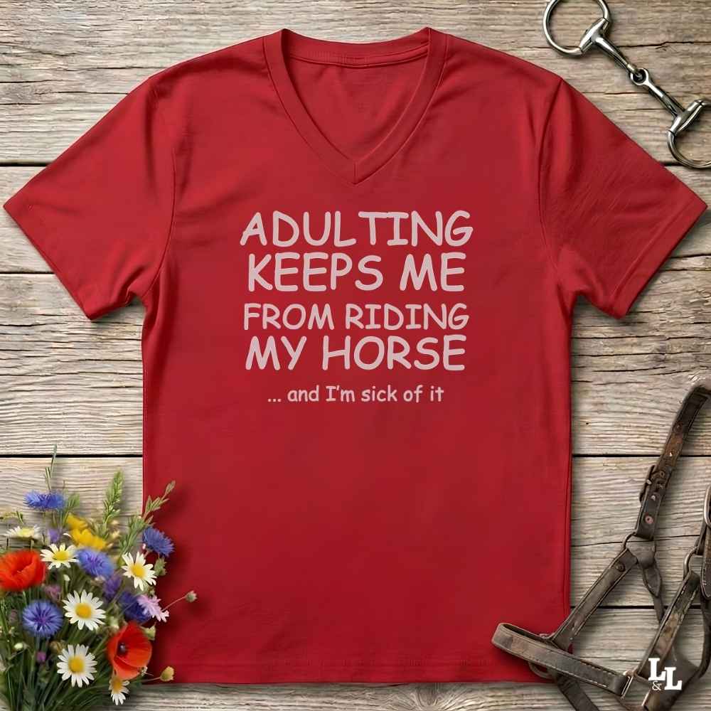 A red V-neck t-shirt with white text reading 'ADULTING KEEPS ME FROM RIDING MY HORSE .