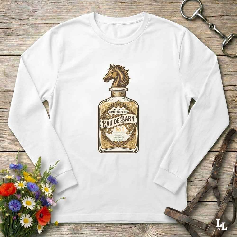 A white long-sleeve t-shirt with a vintage-style graphic of a horse bottle labeled 'Eau de Barn No. 1'.