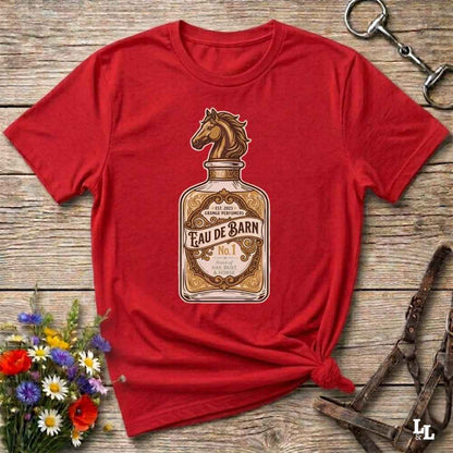 A red short-sleeve t-shirt with a vintage-style graphic of a horse-shaped perfume bottle labeled 'Feau De Barn No. 1'.
