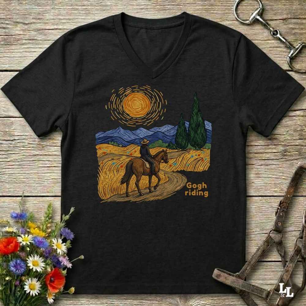 A black V-neck t-shirt with a stylized western landscape graphic on the chest, featuring a rider on a horse, mountains, trees, and a swirling sun. The graphic includes the text 'Gogh riding'.