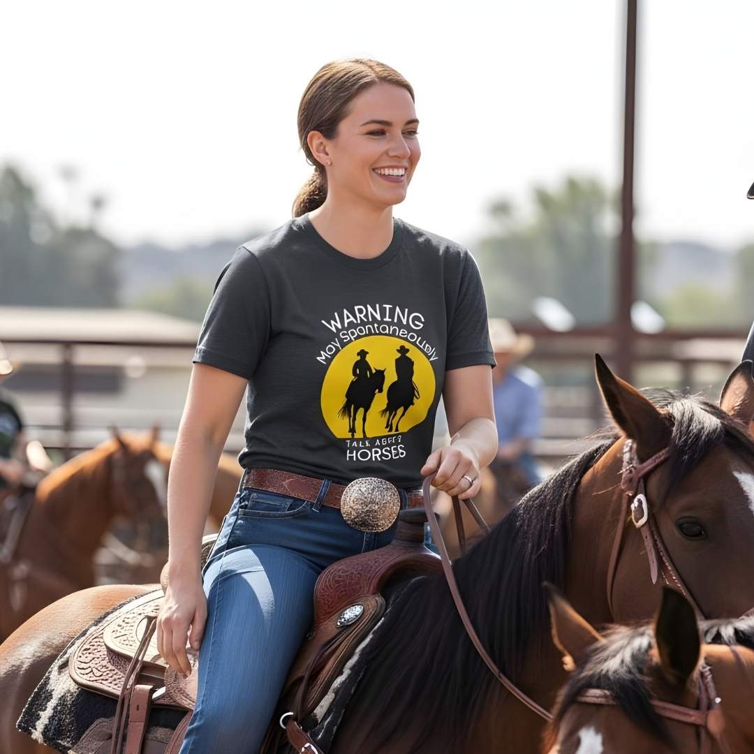 Woman riding a horse wearing a t-shirt with a graphic and text. Warning may Spontaneously talk about Horses Tee. Horse Rider T-Shirt Barn Essential Tee