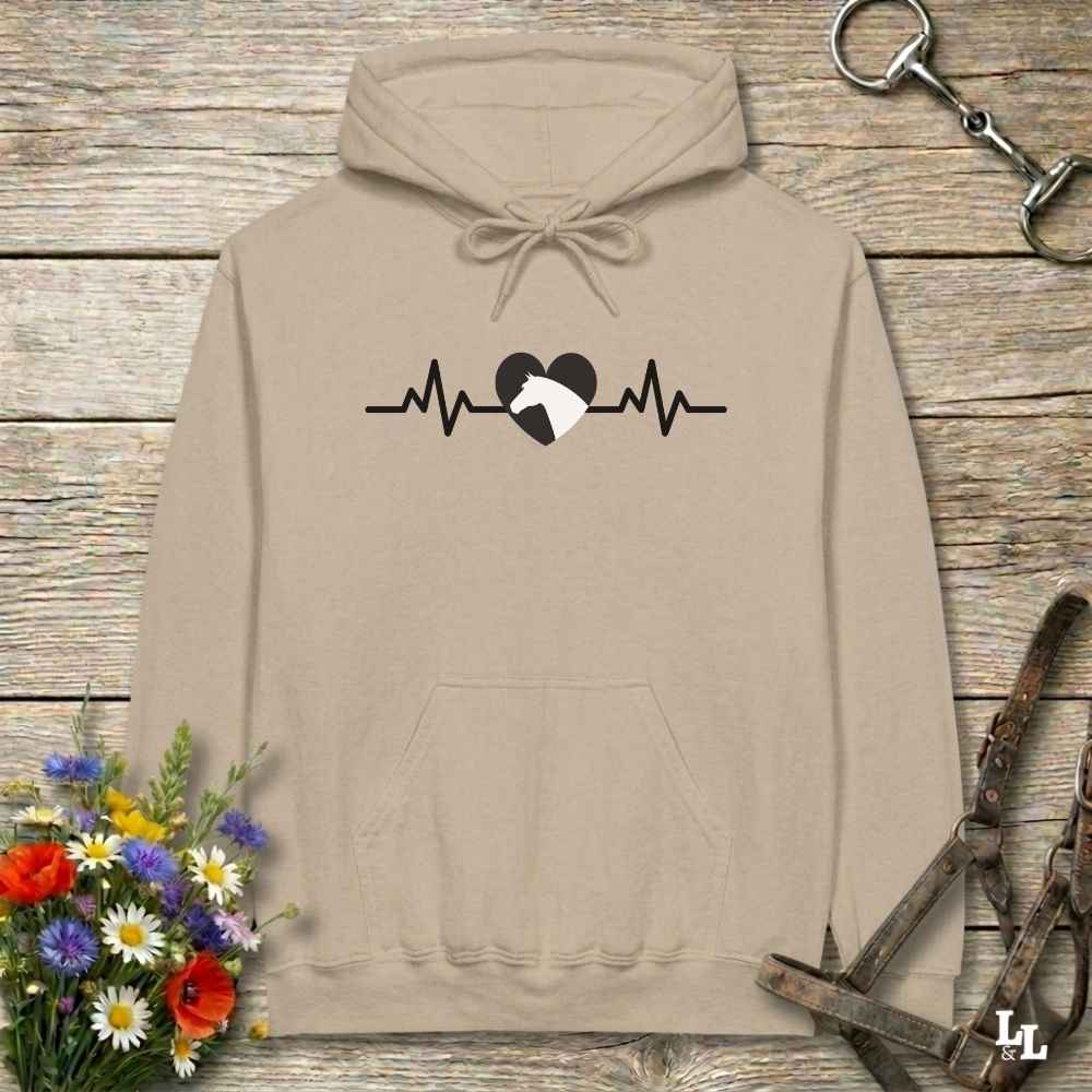 Beige  hoodie with text Heartbeat line and a horse head, on wooden background with equestrian bit and halter and flowers