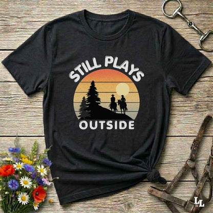 Still plays outside. Funny western t-shirt featuring horse-themed design for cowgirls, cowboys, and equestrians — perfect for rodeo lovers, rustic style fans, and horse people. Unique graphic tee by Lasso and Loom.