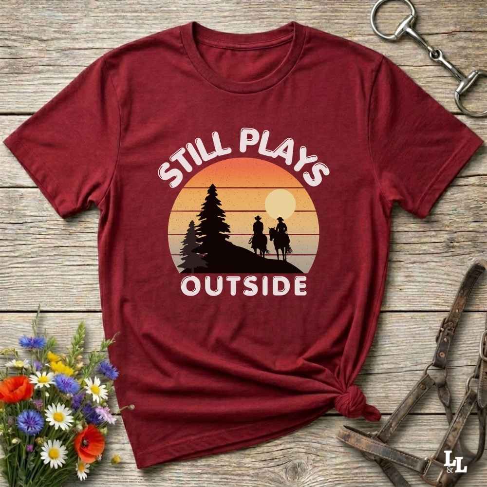 Still plays outside. Funny western t-shirt featuring horse-themed design for cowgirls, cowboys, and equestrians — perfect for rodeo lovers, rustic style fans, and horse people. Unique graphic tee by Lasso and Loom.