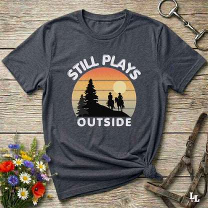 Still plays outside. Funny western t-shirt featuring horse-themed design for cowgirls, cowboys, and equestrians — perfect for rodeo lovers, rustic style fans, and horse people. Unique graphic tee by Lasso and Loom.