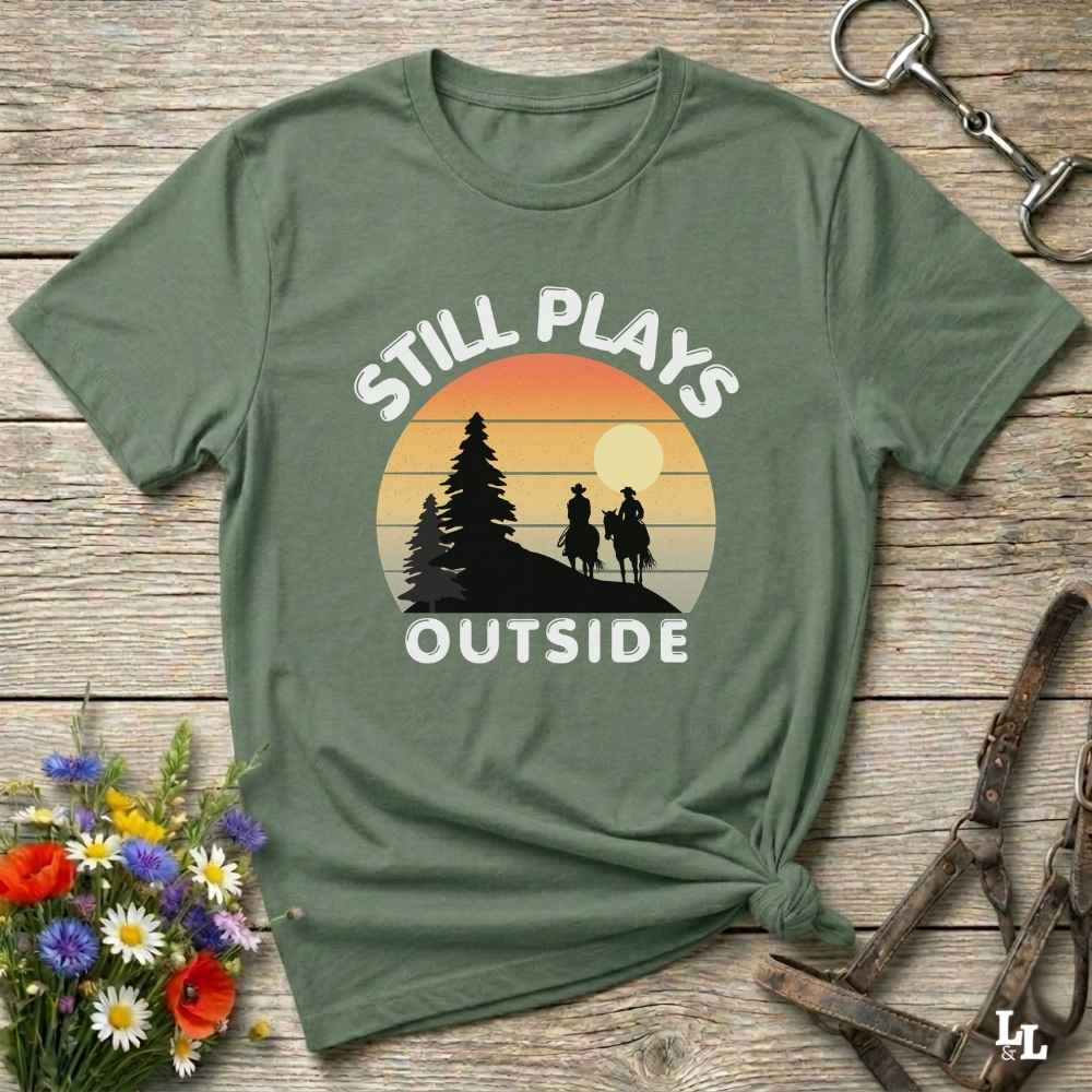 Still plays outside. Funny western t-shirt featuring horse-themed design for cowgirls, cowboys, and equestrians — perfect for rodeo lovers, rustic style fans, and horse people. Unique graphic tee by Lasso and Loom.