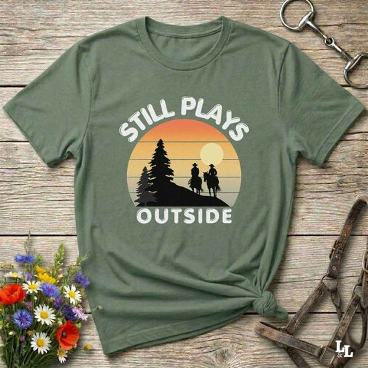 Still plays outside. Funny western t-shirt featuring horse-themed design for cowgirls, cowboys, and equestrians — perfect for rodeo lovers, rustic style fans, and horse people. Unique graphic tee by Lasso and Loom.