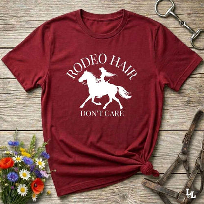 typography cowgirl t-shirt styled for rodeo lovers and horse girls on rustic wooden background. Trendy cowgirl shirt designed for horse lovers, featuring bold western lettering in graphic style. Horse riding themed t-shirt with country slogan “Rodeo Hair Don’t Care” styled for modern cowgirls.