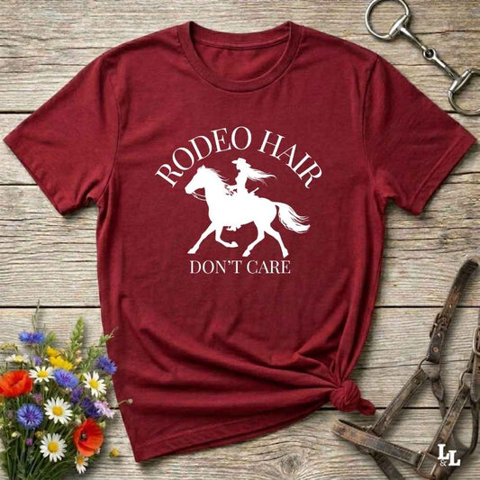 typography cowgirl t-shirt styled for rodeo lovers and horse girls on rustic wooden background. Trendy cowgirl shirt designed for horse lovers, featuring bold western lettering in graphic style. Horse riding themed t-shirt with country slogan “Rodeo Hair Don’t Care” styled for modern cowgirls.
