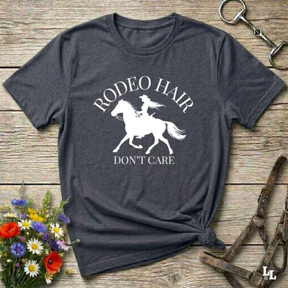 typography cowgirl t-shirt styled for rodeo lovers and horse girls on rustic wooden background. Trendy cowgirl shirt designed for horse lovers, featuring bold western lettering in graphic style. Horse riding themed t-shirt with country slogan “Rodeo Hair Don’t Care” styled for modern cowgirls.