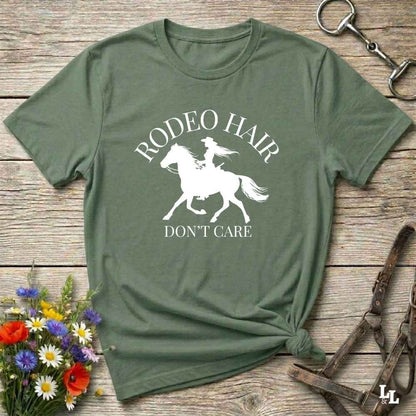 typography cowgirl t-shirt styled for rodeo lovers and horse girls on rustic wooden background. Trendy cowgirl shirt designed for horse lovers, featuring bold western lettering in graphic style. Horse riding themed t-shirt with country slogan “Rodeo Hair Don’t Care” styled for modern cowgirls.