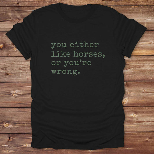 Black t-shirt with text 'you either like horses, or you're wrong.' on a wooden surface. Show your love for horses loud and proud with this funny typography western tee ,perfect for cowgirls, ranchers, and equestrians. 
This “You either like horses or you're wrong” t-shirt is a hilarious must have for horse lovers with sass and sarcasm. Ideal gift for any horse girl or cowboy, this rustic western Gildan tee blends humor with horse life perfectly. Whether you’re mucking stalls or riding trails, this sarcastic
