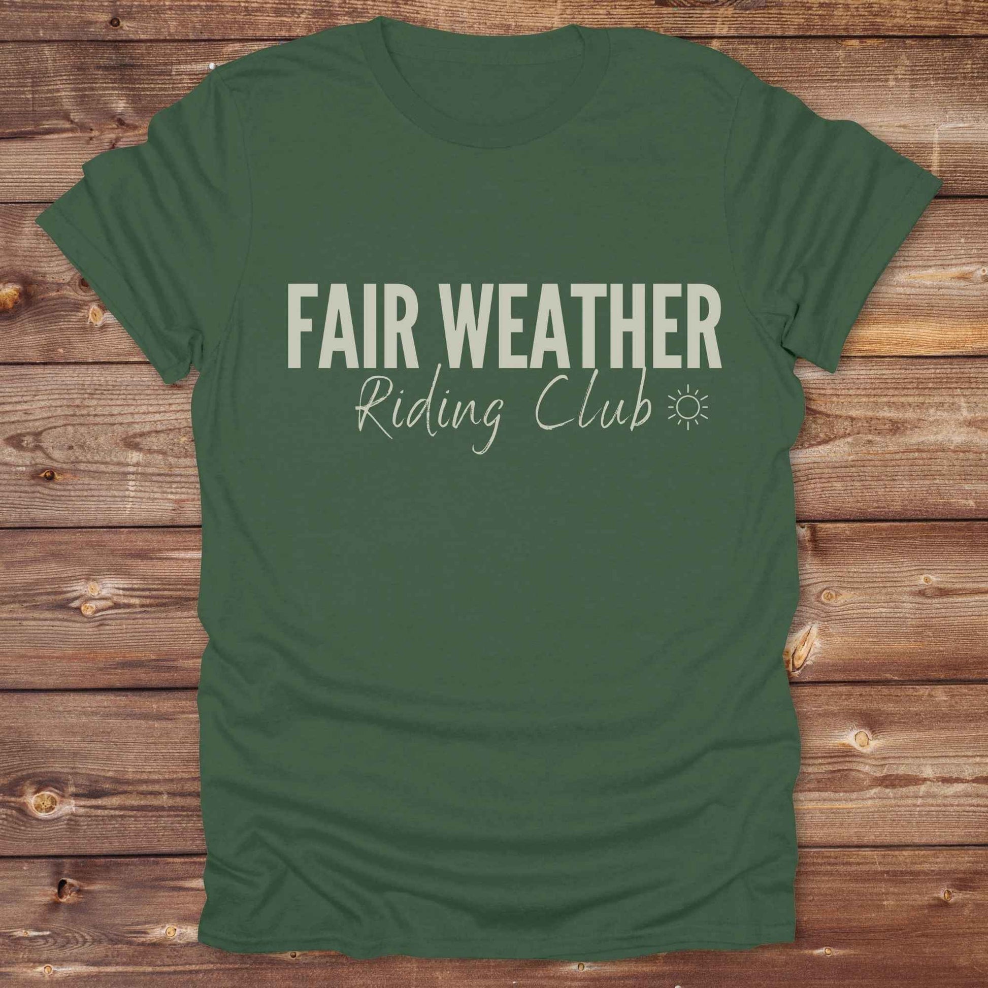 "Fair Weather Riding Club” tee brings western charm and playful equestrian humor together in a bold design that speaks to cowboys and cowgirls alike. erfect for horse lovers who only ride in sunshine. Featuring clean typography and a cute sun icon, it’s the ultimate cowboy core essential for rodeo days, trail rides, or just lounging in the barn. Whether it’s for yourself or as a gift for a fellow rider, this western quote tee adds a sunny twist to any rustic outfit. must have for any modern day trailblazer.