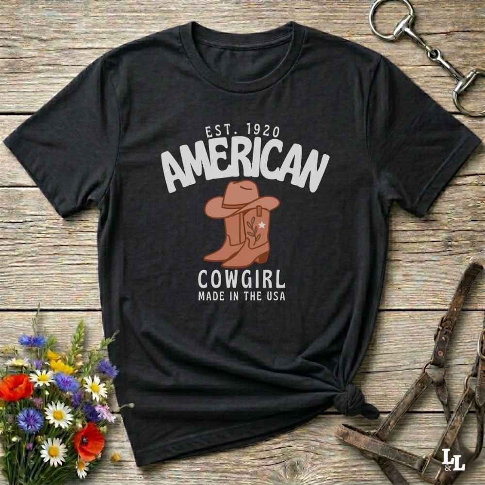 This American Cowgirl T-Shirt is the perfect mix of bold western pride and boho rodeo style. Featuring a rustic boot and hat graphic, it's made for country girls who live for rodeo season and horse rides. It’s a statement piece for cowgirls, country lovers, and western fashion fans alike. Whether you’re gifting it for a birthday or styling it for your next state fair, this tee brings serious cowboy core energy to your closet.  A must have for horse lovers.