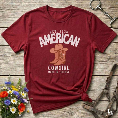 This American Cowgirl T-Shirt is the perfect mix of bold western pride and boho rodeo style. Featuring a rustic boot and hat graphic, it's made for country girls who live for rodeo season and horse rides. It’s a statement piece for cowgirls, country lovers, and western fashion fans alike. Whether you’re gifting it for a birthday or styling it for your next state fair, this tee brings serious cowboy core energy to your closet.  A must have for horse lovers.