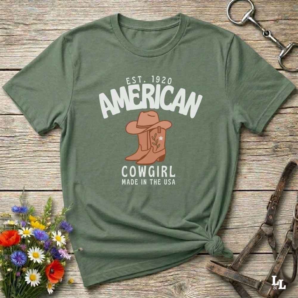 This American Cowgirl T-Shirt is the perfect mix of bold western pride and boho rodeo style. Featuring a rustic boot and hat graphic, it's made for country girls who live for rodeo season and horse rides. It’s a statement piece for cowgirls, country lovers, and western fashion fans alike. Whether you’re gifting it for a birthday or styling it for your next state fair, this tee brings serious cowboy core energy to your closet.  A must have for horse lovers.