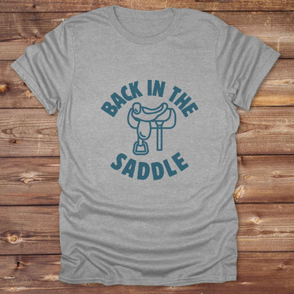 Our "Back in the Saddle" t-shirt is the perfect western-style graphic tee for cowboys and cowgirls who love horseback riding, rodeo culture, and rustic country fashion. Featuring a clean saddle illustration and retro western typography, this shirt blends comfort and character, making it ideal for ranch wear, horse lovers, and rodeo enthusiasts. Whether you're heading to a country concert, festival, or barn, this tee stands out. Makes a great gift for horse riders, western fans or anyone getting back riding