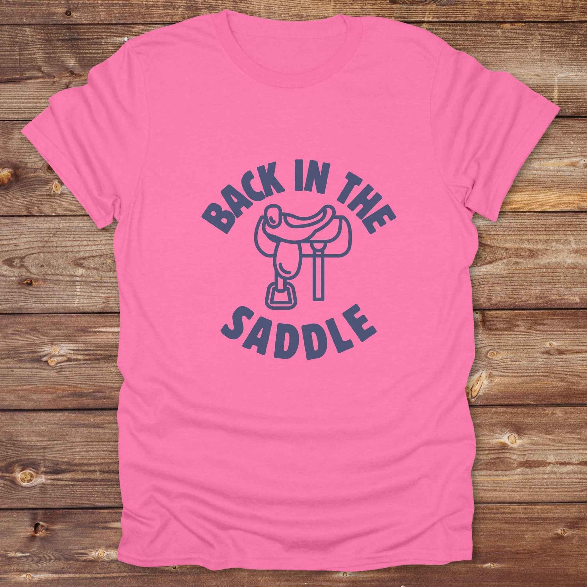 Our "Back in the Saddle" t-shirt is the perfect western-style graphic tee for cowboys and cowgirls who love horseback riding, rodeo culture, and rustic country fashion. Featuring a clean saddle illustration and retro western typography, this shirt blends comfort and character, making it ideal for ranch wear, horse lovers, and rodeo enthusiasts. Whether you're heading to a country concert, festival, or barn, this tee stands out. Makes a great gift for horse riders, western fans or anyone getting back riding