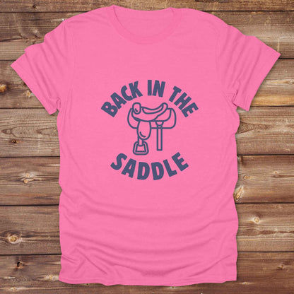 Our "Back in the Saddle" t-shirt is the perfect western-style graphic tee for cowboys and cowgirls who love horseback riding, rodeo culture, and rustic country fashion. Featuring a clean saddle illustration and retro western typography, this shirt blends comfort and character, making it ideal for ranch wear, horse lovers, and rodeo enthusiasts. Whether you're heading to a country concert, festival, or barn, this tee stands out. Makes a great gift for horse riders, western fans or anyone getting back riding