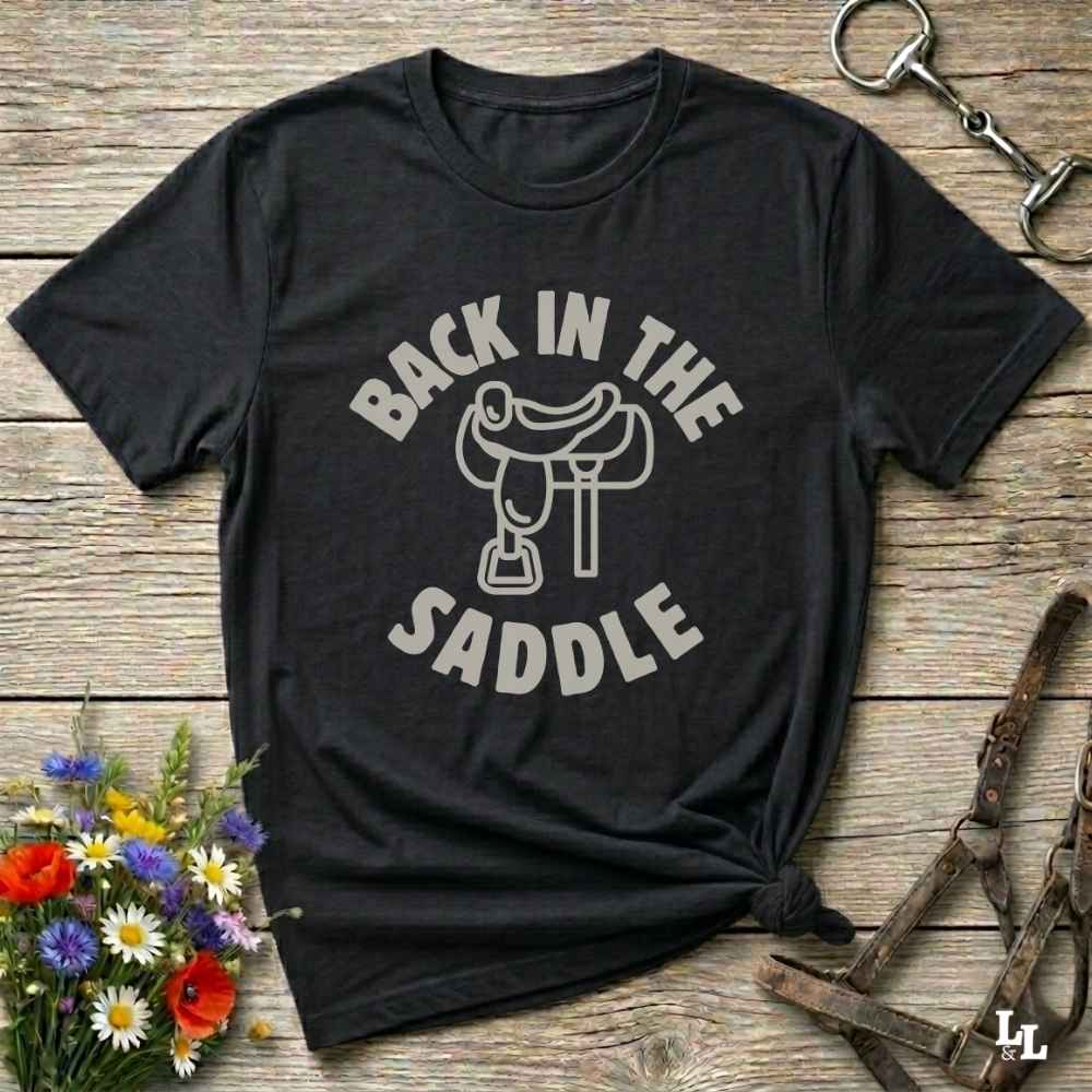 Our "Back in the Saddle" t-shirt is the perfect western-style graphic tee for cowboys and cowgirls who love horseback riding, rodeo culture, and rustic country fashion. Featuring a clean saddle illustration and retro western typography, this shirt blends comfort and character, making it ideal for ranch wear, horse lovers, and rodeo enthusiasts. Whether you're heading to a country concert, festival, or barn, this tee stands out. Makes a great gift for horse riders, western fans or anyone getting back riding