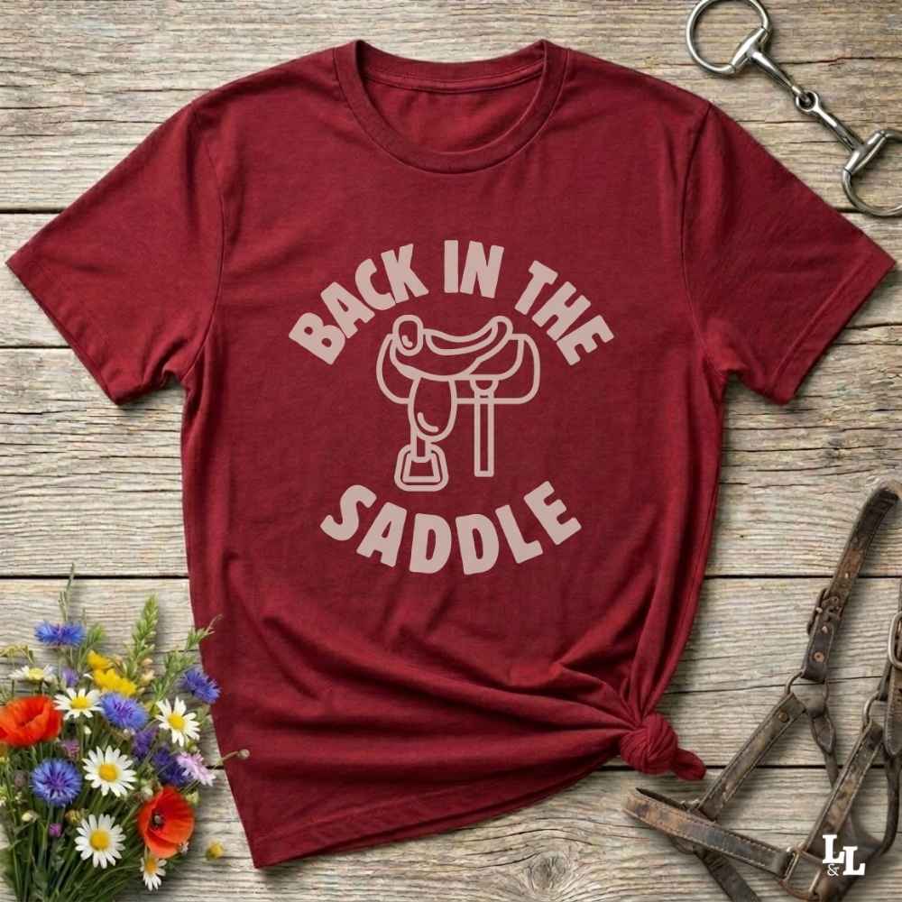 Our "Back in the Saddle" t-shirt is the perfect western-style graphic tee for cowboys and cowgirls who love horseback riding, rodeo culture, and rustic country fashion. Featuring a clean saddle illustration and retro western typography, this shirt blends comfort and character, making it ideal for ranch wear, horse lovers, and rodeo enthusiasts. Whether you're heading to a country concert, festival, or barn, this tee stands out. Makes a great gift for horse riders, western fans or anyone getting back riding