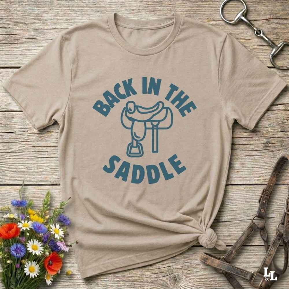 Our "Back in the Saddle" t-shirt is the perfect western-style graphic tee for cowboys and cowgirls who love horseback riding, rodeo culture, and rustic country fashion. Featuring a clean saddle illustration and retro western typography, this shirt blends comfort and character, making it ideal for ranch wear, horse lovers, and rodeo enthusiasts. Whether you're heading to a country concert, festival, or barn, this tee stands out. Makes a great gift for horse riders, western fans or anyone getting back riding