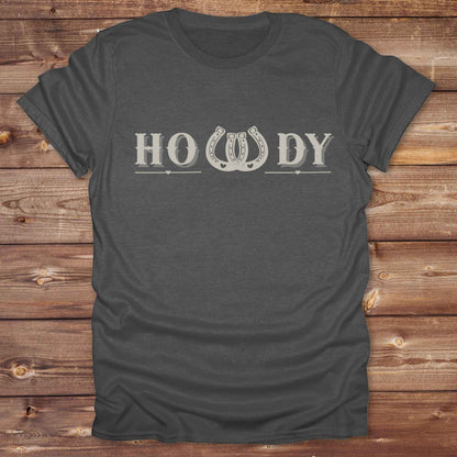 Say “Howdy” in true western style with this rustic horseshoe tee designed for cowboys, cowgirls, and horse lovers alike. Featuring a bold western font and a double horseshoe “W,” this shirt blends southern charm with modern rodeo flair. It's perfect for birthdays, rodeo weekends, country fairs, or just everyday ranch life. Whether you're a rancher, rider, or rural rebel, this shirt adds a little yeehaw to your wardrobe.