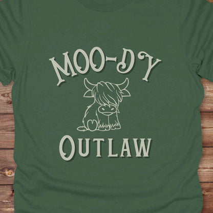 Meet the “Moo-Dy Outlaw” tee from Lasso and Loom a perfect mix of western sass and farmyard fun. Featuring a hand drawn moody Highland cow and outlaw typography, this western graphic tee is made for cowgirls, cowboys, and everyone who rides through life with a little attitude. It's ideal for rodeos, ranch days, and social media selfies with rustic vibes and comfort in every stitch. Whether you're shopping for yourself or gifting a cow lover with a sense of humor, this shirt is guaranteed to wrangle smiles