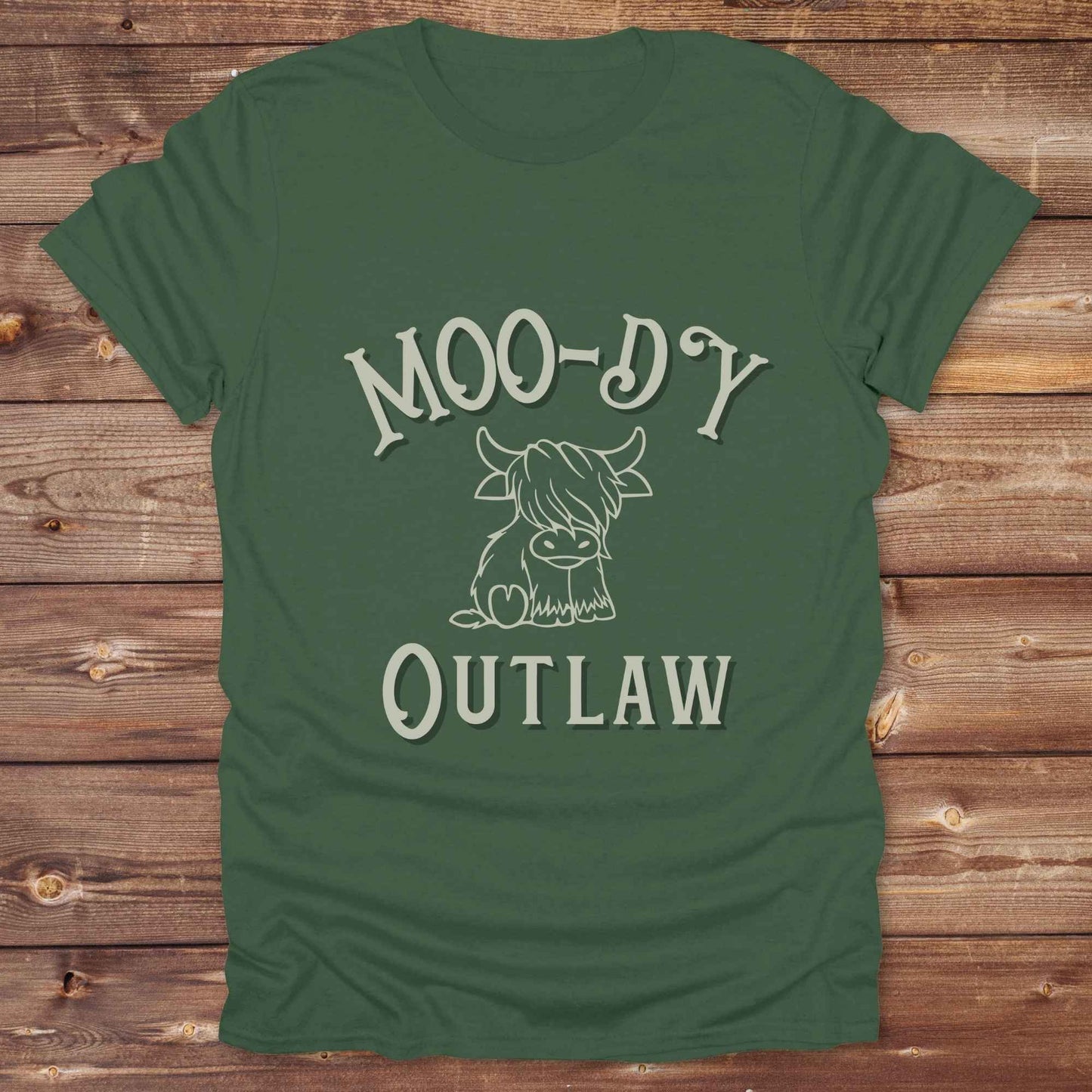 Meet the “Moo-Dy Outlaw” tee from Lasso and Loom a perfect mix of western sass and farmyard fun. Featuring a hand drawn moody Highland cow and outlaw typography, this western graphic tee is made for cowgirls, cowboys, and everyone who rides through life with a little attitude. It's ideal for rodeos, ranch days, and social media selfies with rustic vibes and comfort in every stitch. Whether you're shopping for yourself or gifting a cow lover with a sense of humor, this shirt is guaranteed to wrangle smiles