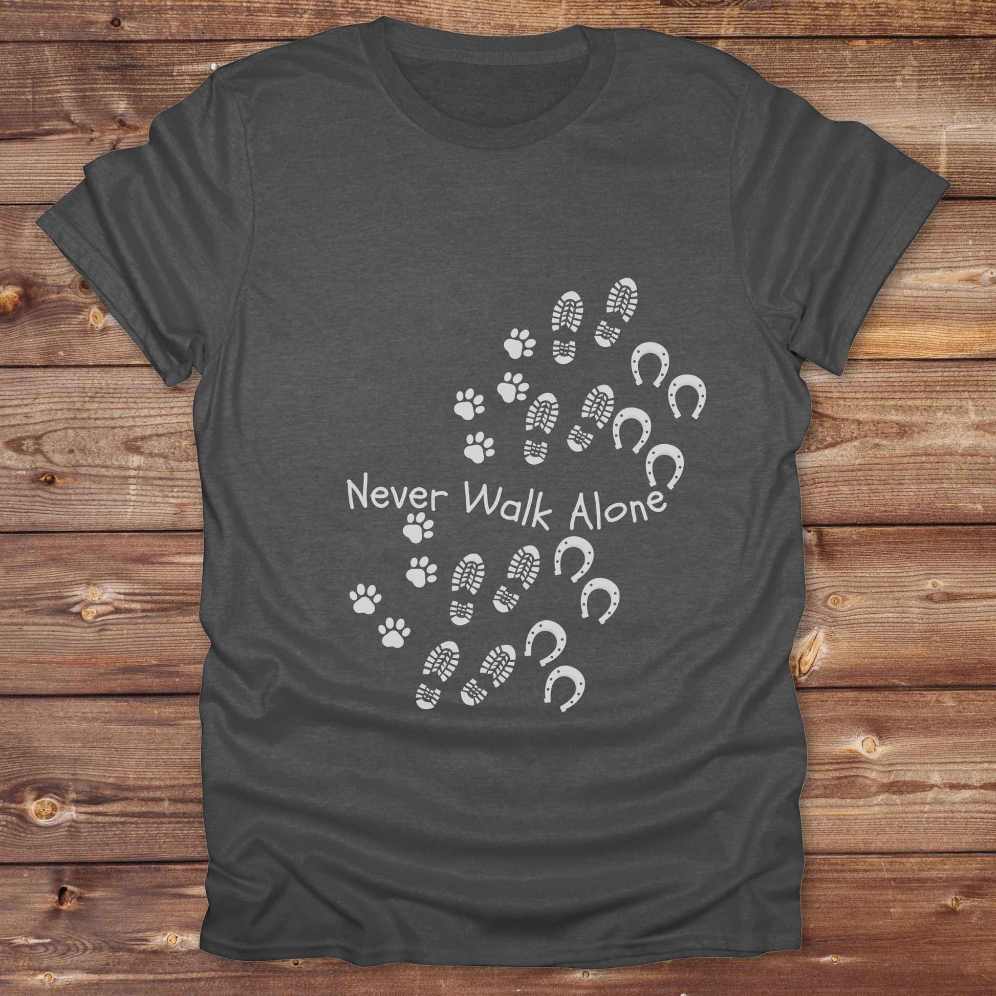 Celebrate the unbreakable bond between dogs, horses, and their human companions with this heartfelt "Never Walk Alone" western-style t-shirt. Featuring boot, paw, and hoof prints in a soft rustic print, this tee is perfect for cowgirls, dog moms, horse lovers, and equestrian trail riders alike. Whether you're walking through a ranch, riding across fields, or heading to the stables, this shirt is a perfect fit for your country lifestyle. Makes a thoughtful gift for birthdays, pet memorials, and western pet l