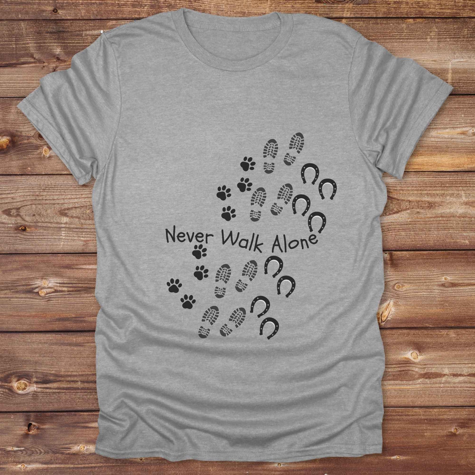 Celebrate the unbreakable bond between dogs, horses, and their human companions with this heartfelt "Never Walk Alone" western-style t-shirt. Featuring boot, paw, and hoof prints in a soft rustic print, this tee is perfect for cowgirls, dog moms, horse lovers, and equestrian trail riders alike. Whether you're walking through a ranch, riding across fields, or heading to the stables, this shirt is a perfect fit for your country lifestyle. Makes a thoughtful gift for birthdays, pet memorials, and western pet l