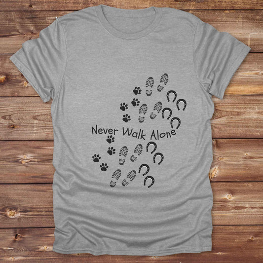 Celebrate the unbreakable bond between dogs, horses, and their human companions with this heartfelt "Never Walk Alone" western-style t-shirt. Featuring boot, paw, and hoof prints in a soft rustic print, this tee is perfect for cowgirls, dog moms, horse lovers, and equestrian trail riders alike. Whether you're walking through a ranch, riding across fields, or heading to the stables, this shirt is a perfect fit for your country lifestyle. Makes a thoughtful gift for birthdays, pet memorials, and western pet l