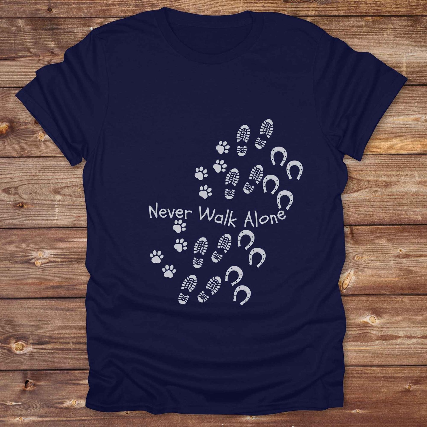 Celebrate the unbreakable bond between dogs, horses, and their human companions with this heartfelt "Never Walk Alone" western-style t-shirt. Featuring boot, paw, and hoof prints in a soft rustic print, this tee is perfect for cowgirls, dog moms, horse lovers, and equestrian trail riders alike. Whether you're walking through a ranch, riding across fields, or heading to the stables, this shirt is a perfect fit for your country lifestyle. Makes a thoughtful gift for birthdays, pet memorials, and western pet l