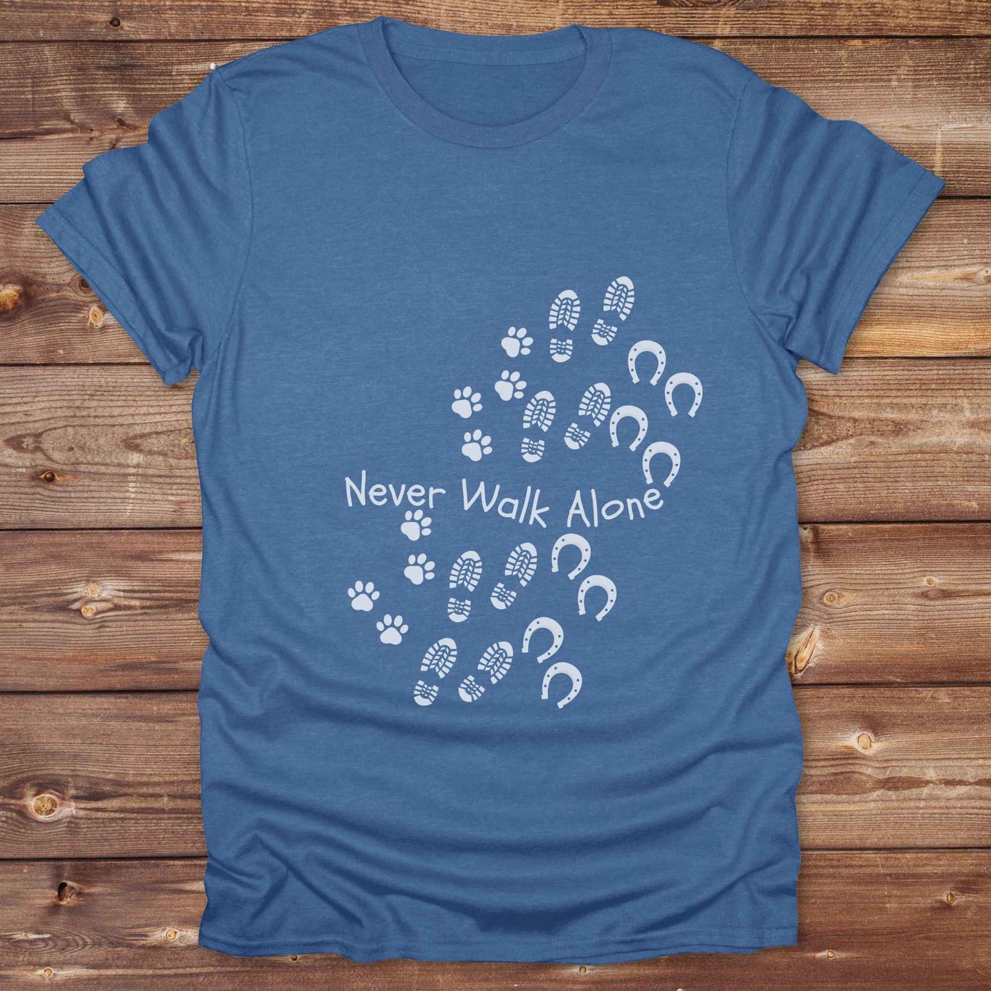Celebrate the unbreakable bond between dogs, horses, and their human companions with this heartfelt "Never Walk Alone" western-style t-shirt. Featuring boot, paw, and hoof prints in a soft rustic print, this tee is perfect for cowgirls, dog moms, horse lovers, and equestrian trail riders alike. Whether you're walking through a ranch, riding across fields, or heading to the stables, this shirt is a perfect fit for your country lifestyle. Makes a thoughtful gift for birthdays, pet memorials, and western pet l