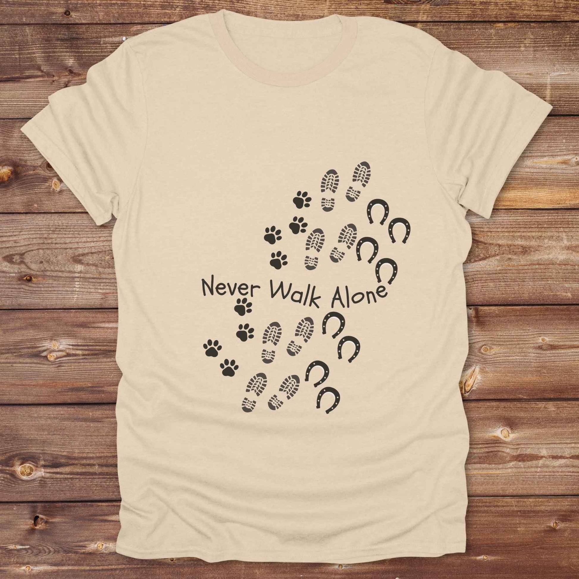 Celebrate the unbreakable bond between dogs, horses, and their human companions with this heartfelt "Never Walk Alone" western-style t-shirt. Featuring boot, paw, and hoof prints in a soft rustic print, this tee is perfect for cowgirls, dog moms, horse lovers, and equestrian trail riders alike. Whether you're walking through a ranch, riding across fields, or heading to the stables, this shirt is a perfect fit for your country lifestyle. Makes a thoughtful gift for birthdays, pet memorials, and western pet l