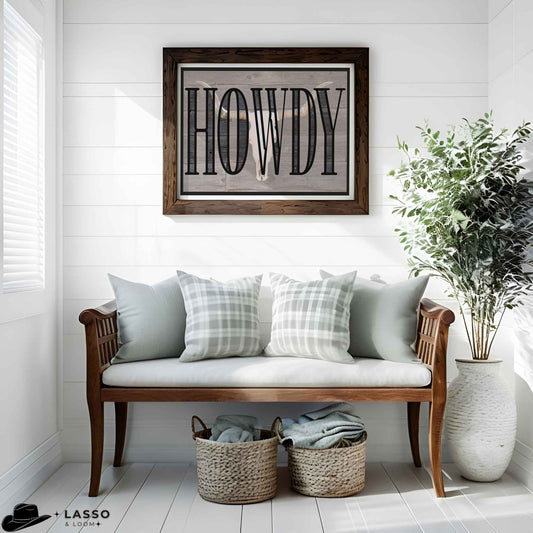 Western style wall art featuring bold "Howdy" typography over a rustic longhorn skull image on a wooden background. Printable cowboy aesthetic art with a bull skull and large "Howdy" lettering, ideal for farmhouse or country homes. Southwestern decor.